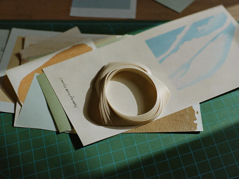 Blank paper craft kit with cut papers, bone folder and green cutting mat