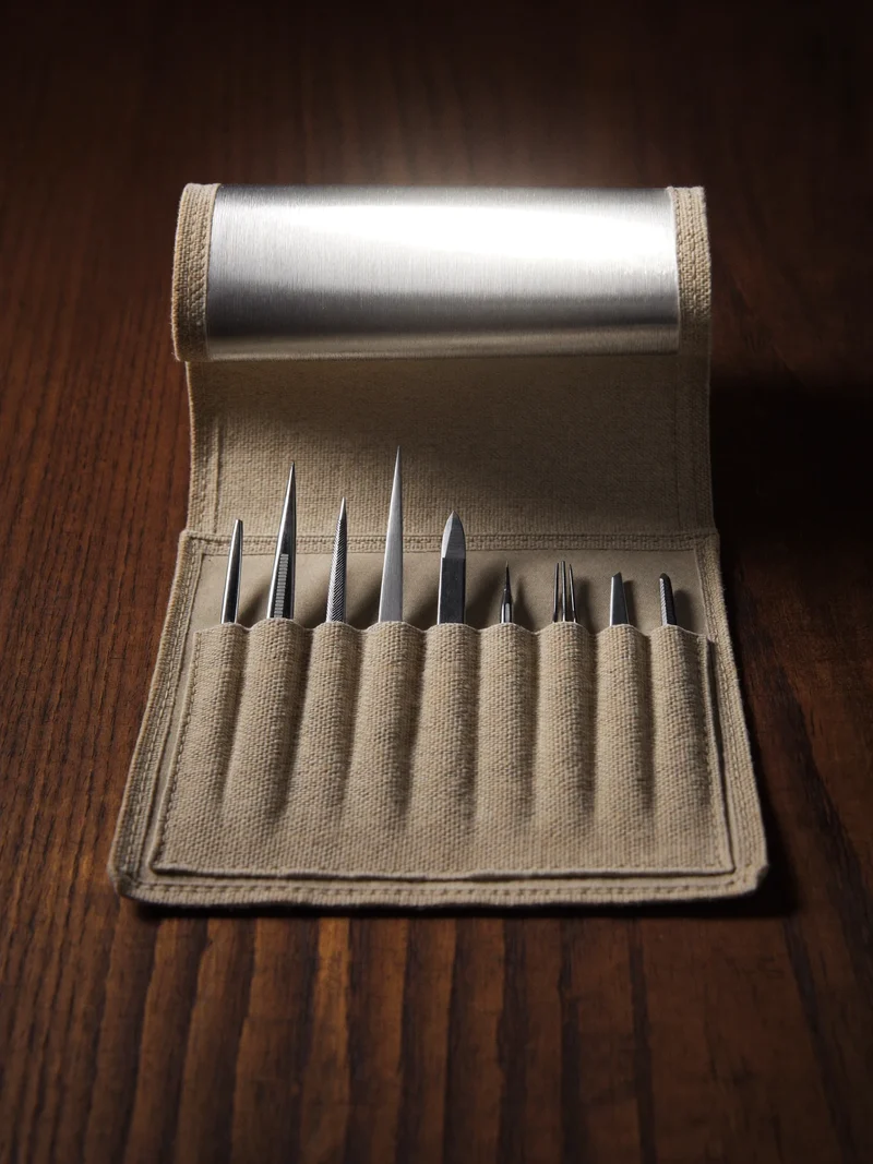 Opened canvas tool roll holding tweezers, micro scissors and needle files